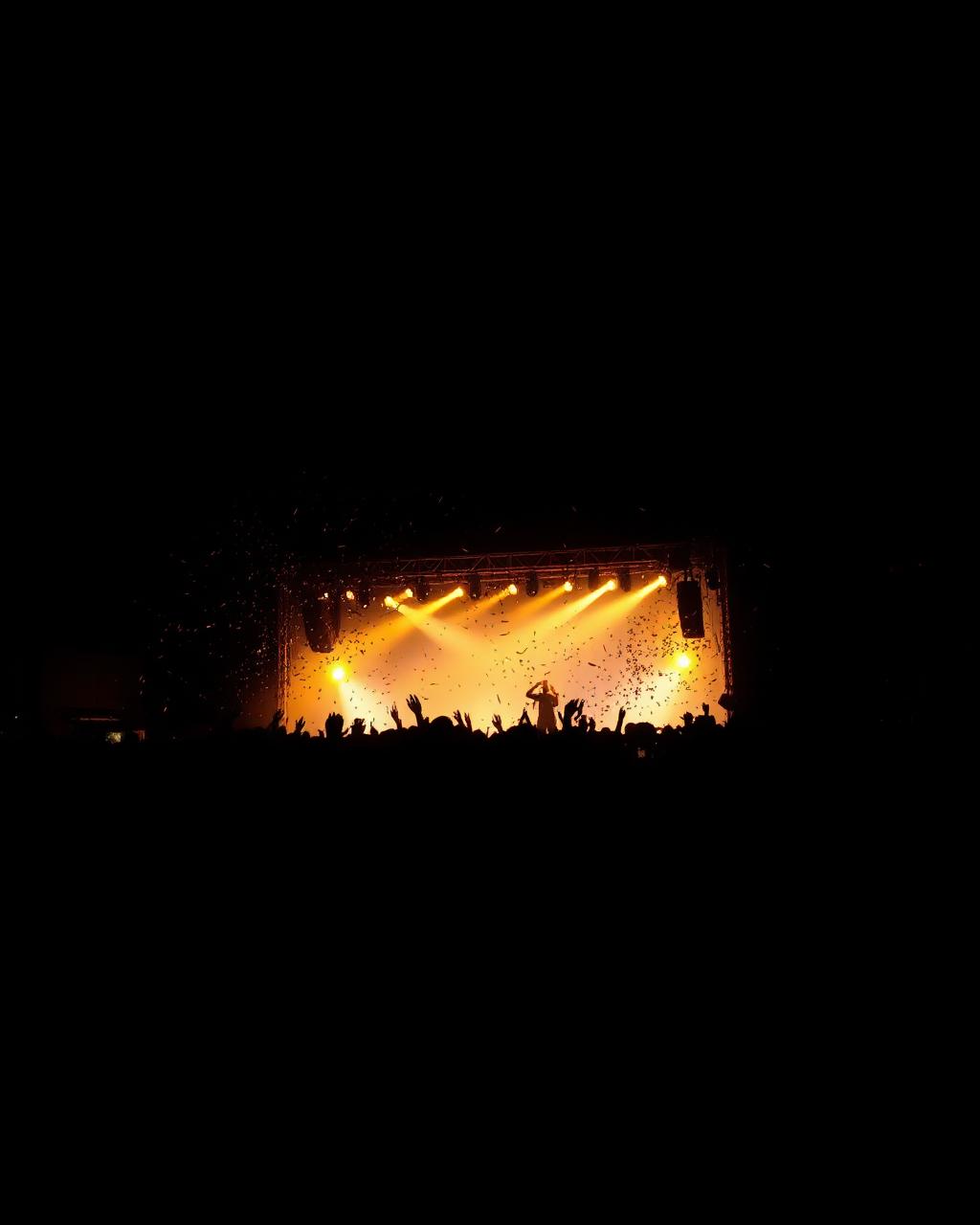 Concert crowd under golden stage lights